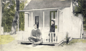 Bernard (seated) with his daughter Renee (standing). They are outside a large playhouse.