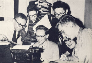 Ticker staff working around a typewriter.