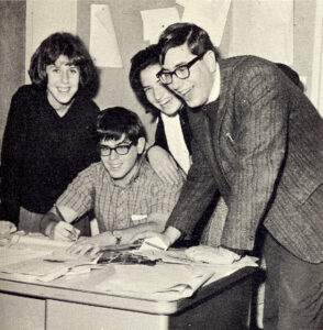 Four Ticker Staff posing around a desk.