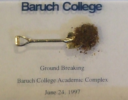 Souvenir from groundbreaking ceremony. The clump of dirt rests on top a tiny gold shovel.